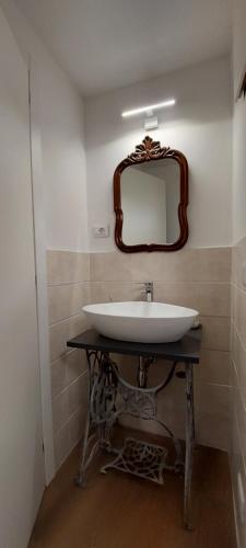 a bathroom with a sink and a mirror on the wall at Via Castello Appartamento da Mary in Montecreto