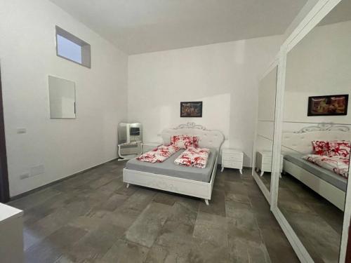 Habitación blanca con 2 camas y espejo. en Picobello, en Cellino San Marco