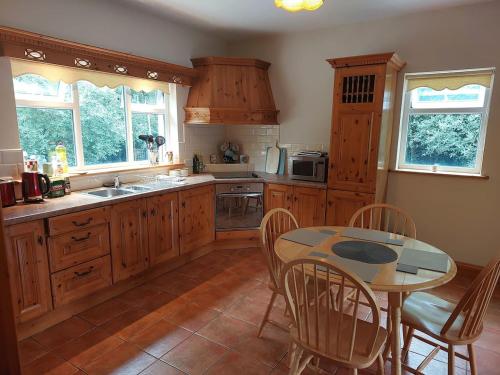 a kitchen with wooden cabinets and a table with chairs at Home in Ennis in Ennis