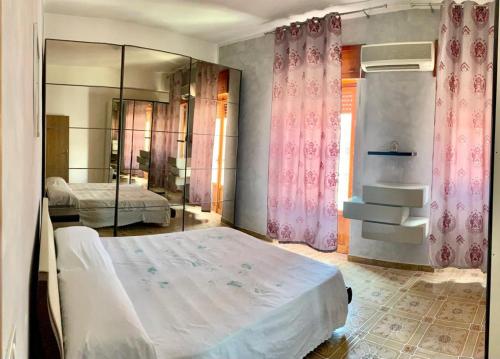 a bedroom with a bed and a mirror at Casa graziella in Peschici