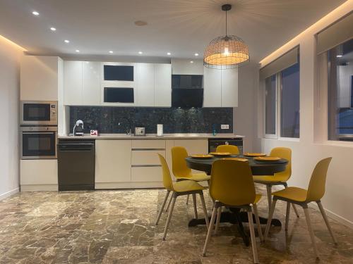 uma cozinha com uma mesa de jantar e cadeiras amarelas em Del Mar three bed flat. em Puerto de Sagunto