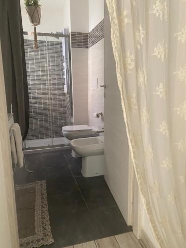 a white bathroom with a toilet and a shower at MAISON REBECCA in Carpi
