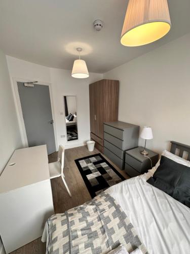 a bedroom with a bed and a desk and a room at Double and single rooms in Bromley by bow in London