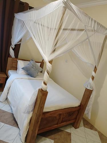 - une chambre avec un lit et une moustiquaire dans l'établissement ULTRA HOME-Private House, à Arusha