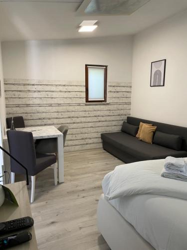 a bedroom with a bed and a table and a couch at Aspen Studio Apartment + FREE Parking in Ljubljana