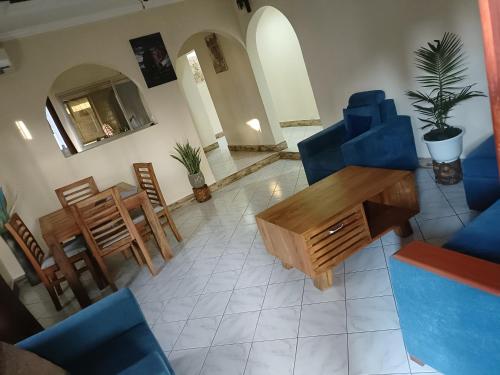 - un salon avec des chaises bleues et une table dans l'établissement ULTRA HOME-Private House, à Arusha