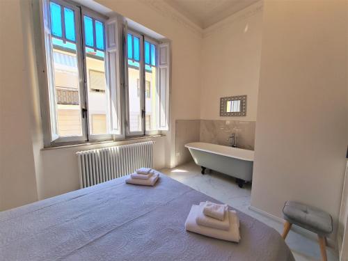 a bedroom with a bed and a tub and a window at Allegra Viareggio Appartamento & Affittacamere Guest house in Viareggio