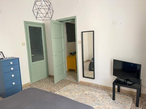 - une chambre avec une télévision, une commode et un miroir dans l'établissement 10 MAGGIO APARTMENTS, à Augusta