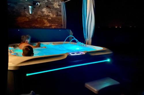 un enfant dans une baignoire avec une lumière bleue dans l'établissement LA BOURIOTE - L'ETABLE, à Villefranche-dʼAlbigeois