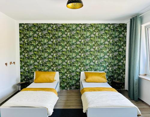 ドルトムントにあるFair, University, BVBの花の壁が備わる客室内のベッド2台