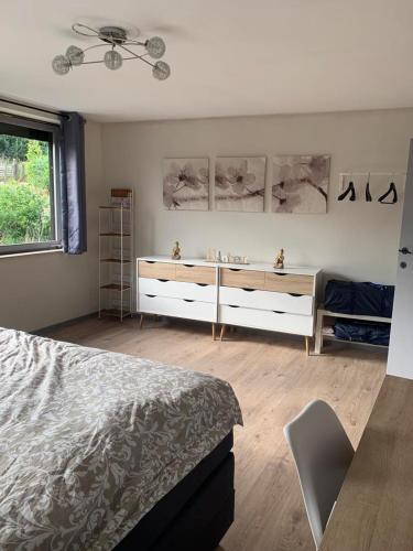 a bedroom with a bed and a dresser and a window at Au Repos de la Redoute in Aywaille