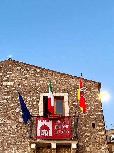 a building with flags hanging from a window at Tyche House Castelmola in Castelmola