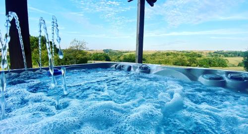 une baignoire jacuzzi avec vue sur la campagne dans l'établissement LA BOURIOTE - L'ETABLE, à Villefranche-dʼAlbigeois