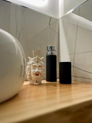 a mask sitting on top of a wooden table at Tyche House Castelmola in Castelmola