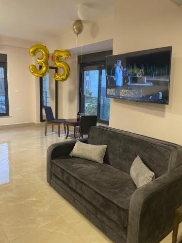 a living room with a couch and a tv at Mizirawi Historic Hotel in Ramallah