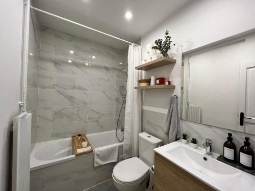 ein Badezimmer mit einer Badewanne, einem WC und einem Waschbecken in der Unterkunft Maison Paris Jeux Olympiques in Othis