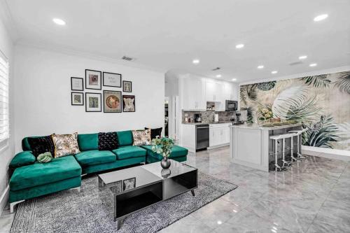 a living room with a green couch and a kitchen at Miami Luxury Home! Next to Miami airport and beach in Miami