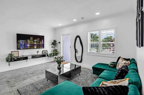 a living room with a green couch and a mirror at Miami Luxury Home! Next to Miami airport and beach in Miami
