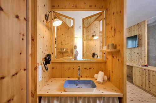 a wooden bathroom with a sink and a mirror at Hotel Der Einrichter in Straubing