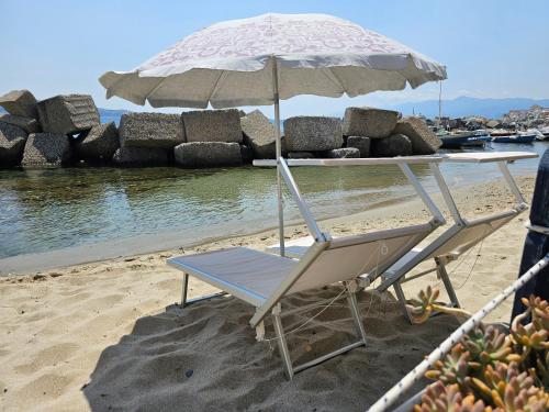 een stoel en een parasol op het strand bij Casa di Nonna Mariella in Messina