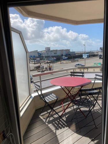 d'une table et de chaises sur un balcon avec vue sur le parking. dans l'établissement Appartement idéalement placé sur le port, à La Turballe