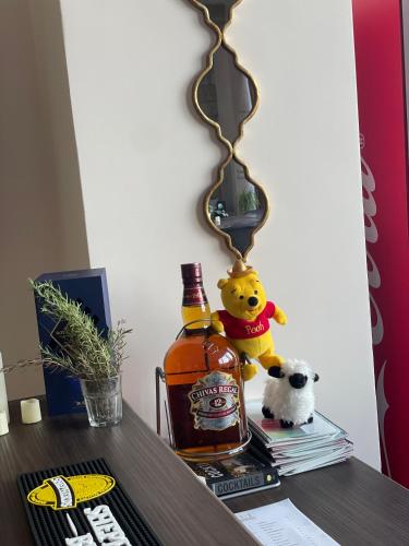 a stuffed bear sitting on a table next to a bottle of whiskey at Mizirawi Historic Hotel in Ramallah