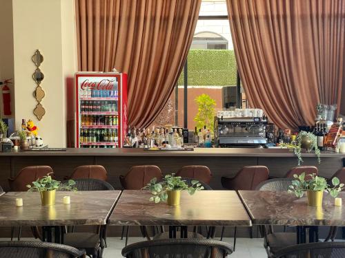 a restaurant with two tables and a bar with red curtains at Mizirawi Historic Hotel in Ramallah