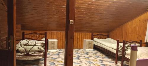 two beds in a room with wooden walls at Chalet's lake_Bolu Abant _log house in Piroğlu