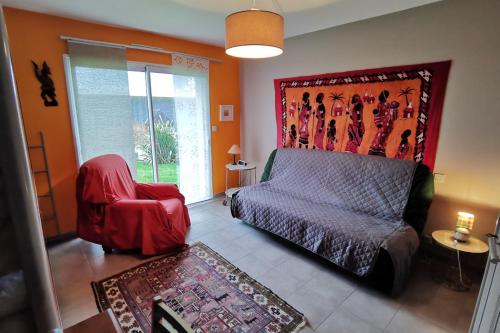 Maison Kermajo في Plougastel-Daoulas: غرفة نوم بسرير وكرسي احمر