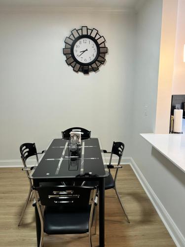 a table with chairs and a clock on a wall at South Charlotte’s Cozy & Modern in Charlotte