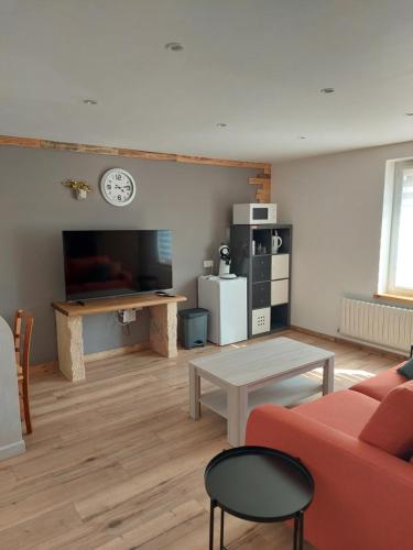 un salon avec un canapé rouge et une table dans l'établissement Les hirondelles, à Laquenexy