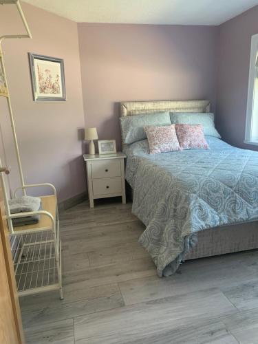 a bedroom with a bed and a table and a chair at Farsnagh Cottage in Newport Trench