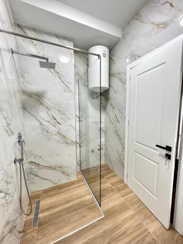 a shower with a glass door in a bathroom at George apartments2023/2 in Korçë