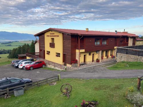 a building with cars parked in a parking lot at Penzión pod Barancom in Žiar