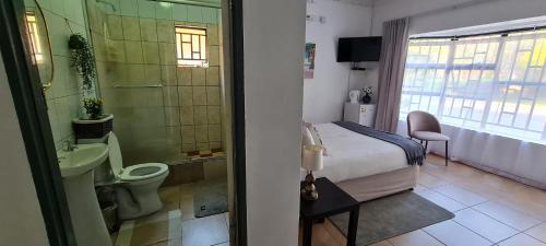 ein Bad mit einem Bett, einem WC und einem Waschbecken in der Unterkunft Thamalakane guest house in Maun