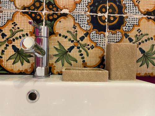 un lavandino in bagno con rubinetto e due asciugamani sopra di Casa Giagantini a Scicli