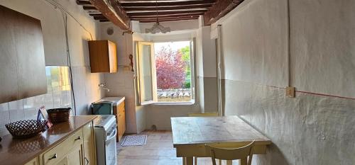une cuisine avec une table et une fenêtre dans l'établissement La casa di Francesco, à Sassoferrato