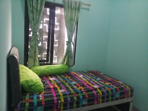 Bett in einem Zimmer mit Fenster in der Unterkunft Guest House Murah -homestay - Kos harian 