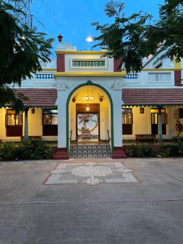a building with an arch with a painting on it at Marutham Village Resort in Mahabalipuram