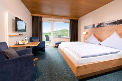 a hotel room with a bed and a tv at Seehotel am Stausee 4 Sterne Superior in Gerolstein