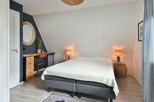 a bedroom with a bed and a table and a mirror at Beachhouse Zonneweelde in Noordwijk