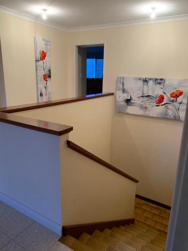 a staircase in an office with paintings on the wall at Ocean Vista Beach Stay in Rockingham