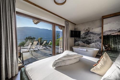 a bedroom with a bed and a balcony with a tub at Chalets & Apartments Wachterhof in Kaltenbach