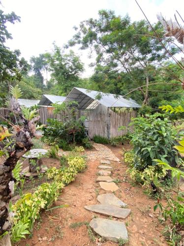 a garden with a fence and a stone path at Green Valley Veal Pouch in Kampot