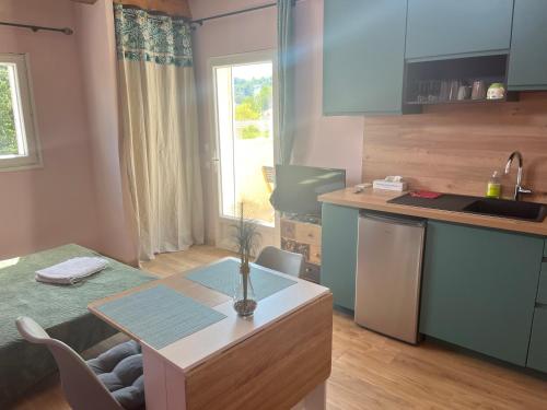 une cuisine avec une table et un comptoir dans l'établissement Studio terrasse avec une vue dégagée 3km Avignon, à Villeneuve-lès-Avignon