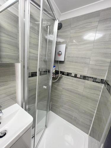 a bathroom with a shower and a sink at Deluxe Ringwood Rooms in Hackbridge