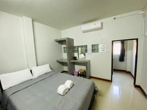 ein Schlafzimmer mit einem Bett mit zwei Handtüchern darauf in der Unterkunft เกรซรูม รีสอร์ท (Grace Room Resort) 