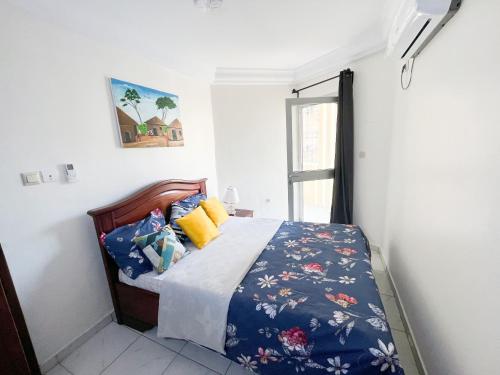 um quarto com uma cama com um edredão azul em Studio Cosy centre AKWA em Douala