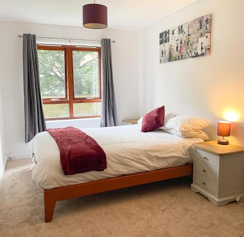 um quarto com uma cama e uma janela em Spacious, central and newly decorated apartment em Edinburgo