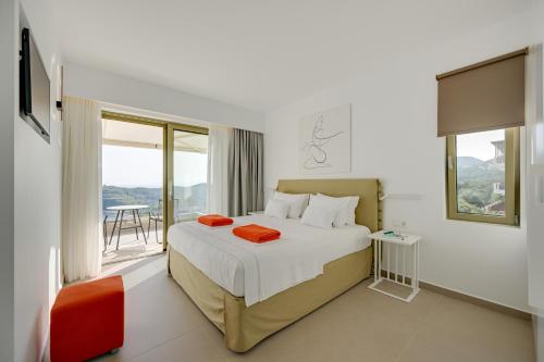 1 dormitorio con cama y ventana grande en LIVINGHOME SUITES, en Parga